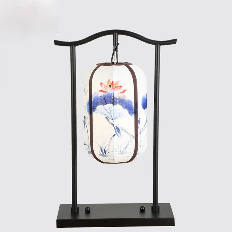 Decorative lamp with floral design on a black stand against a light gray background