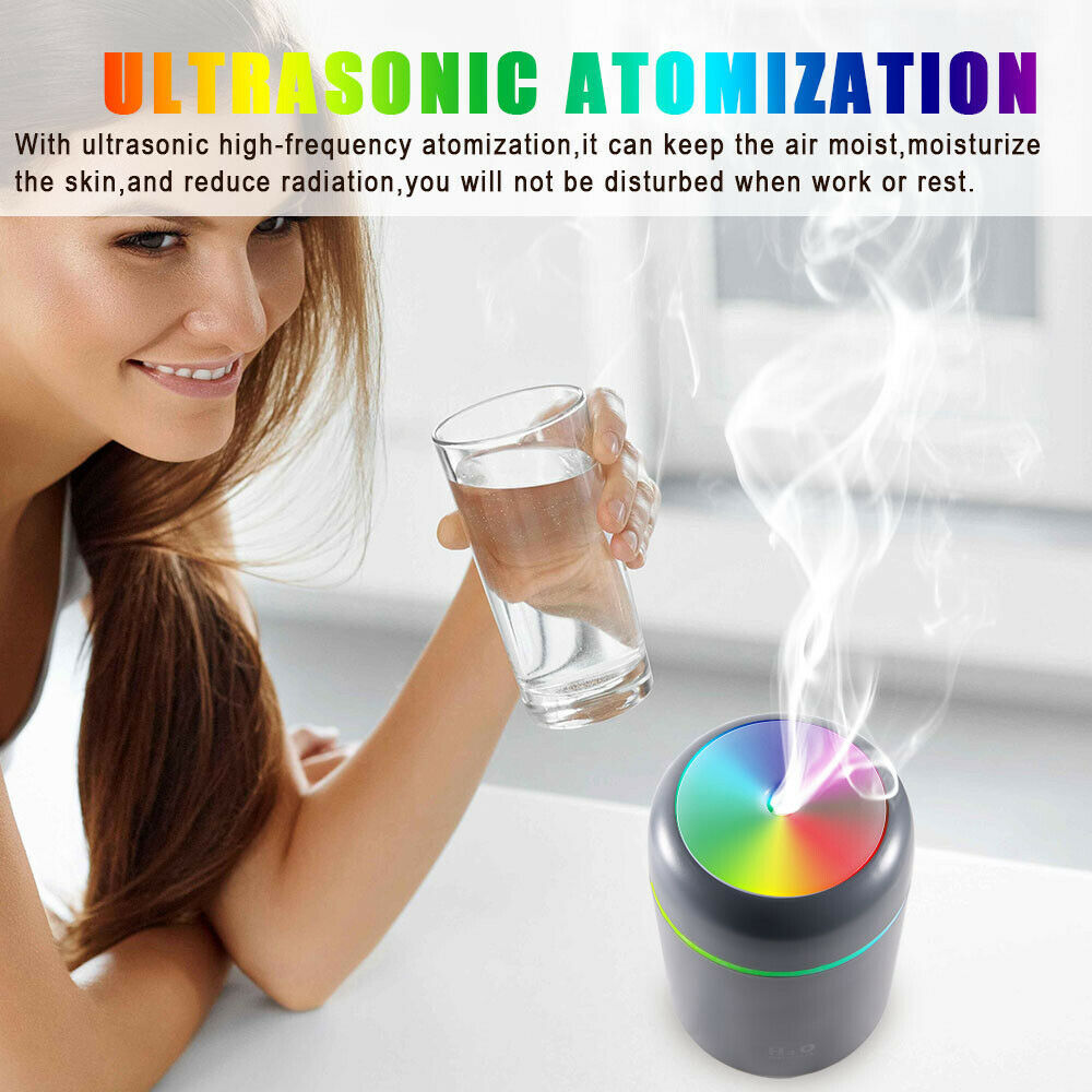 Woman holding a glass of water next to an ultrasonic atomization device with colorful light display.