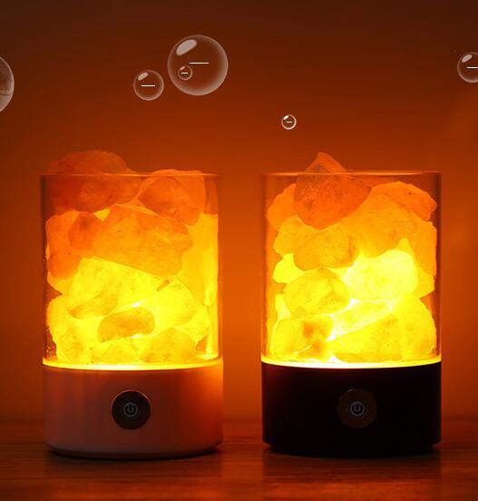 Picture of 2 salt lamps, lit up with amber glow.