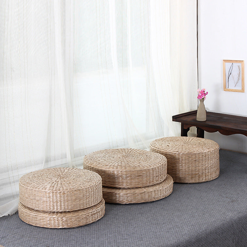 Set of woven ottomans in a room with white curtains and a small table.