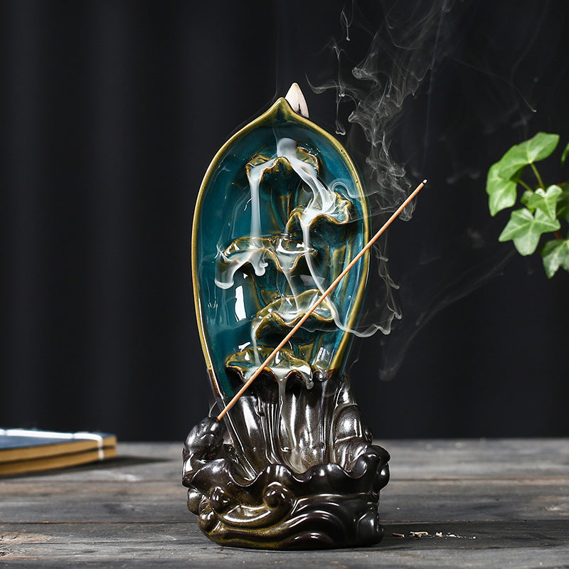 Decorative incense burner with smoke on a dark background sitting on a table