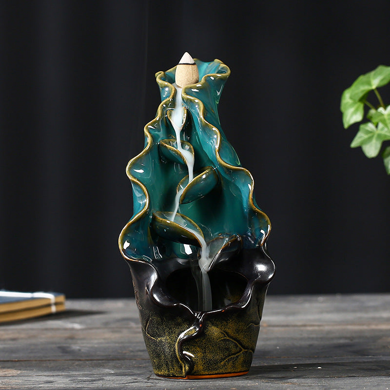 Ceramic water fountain with decorative design on a wooden surface
