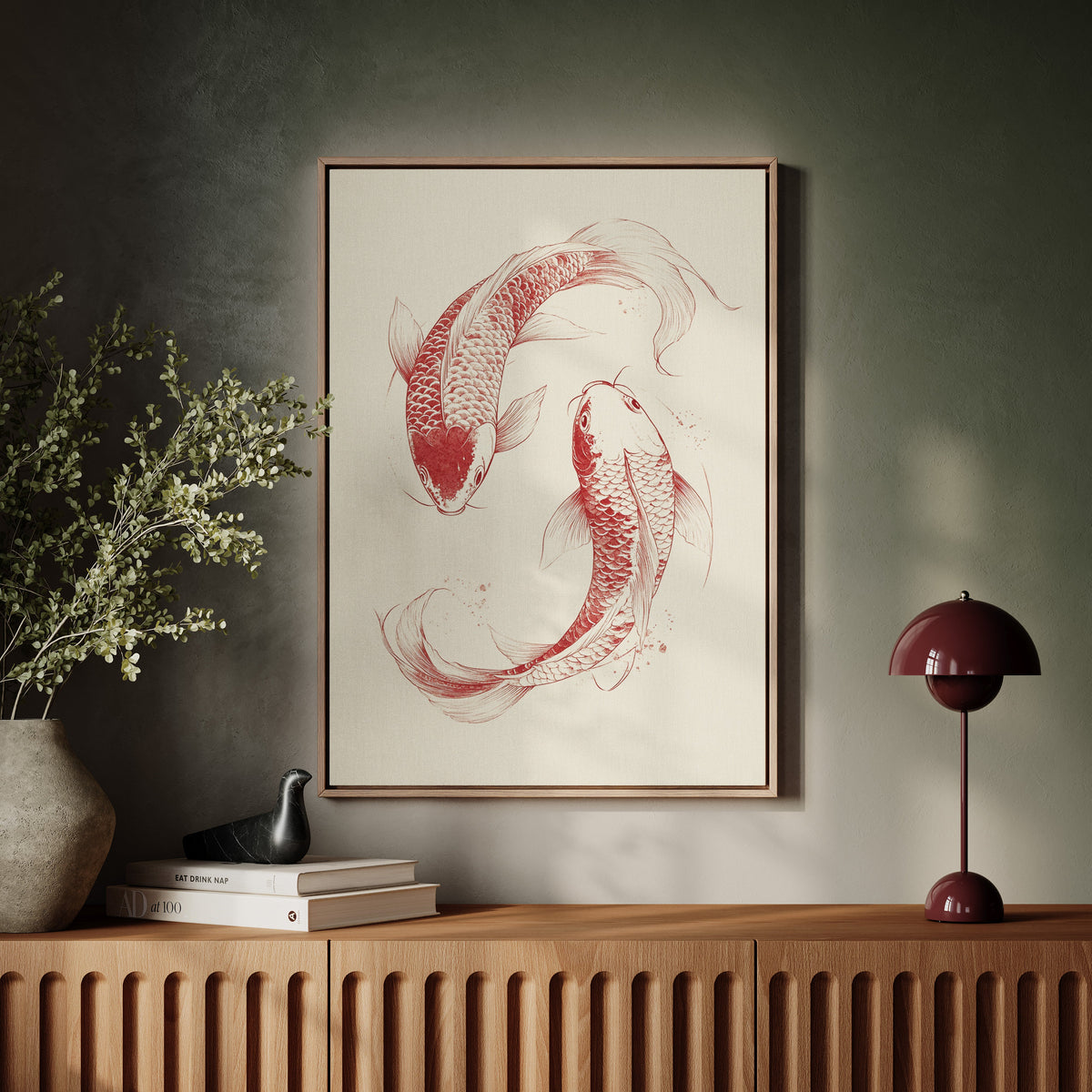 Framed artwork of two red koi fish on a wall above a wooden console table.