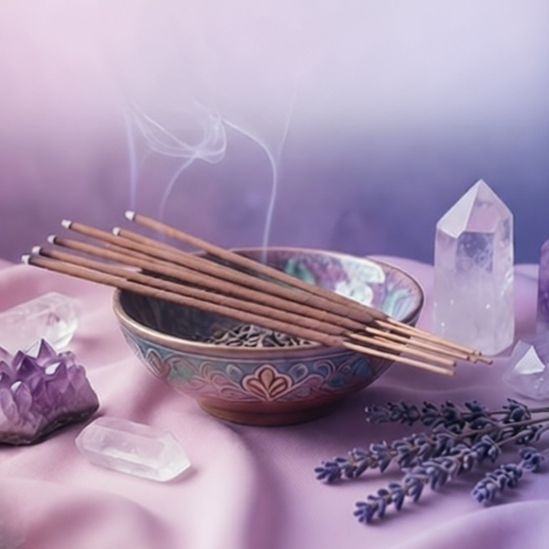 Six lit incense sticks lying across a small bowl next to some crystals.