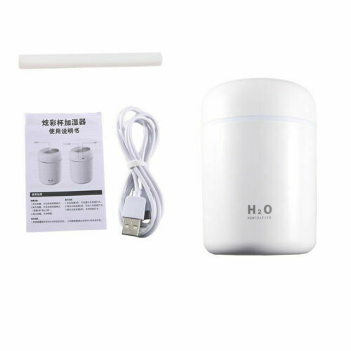 A white cylindrical humidifier container shown with a USB charging cable, a replacement filter stick, and an instruction booklet on a plain white background.