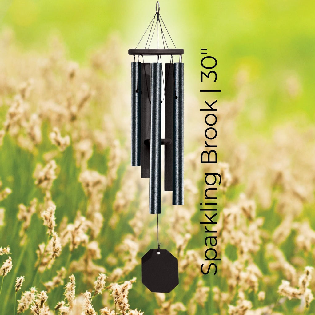 Black wind chime labeled 'Sparkling Brook 30"' against a blurred natural background