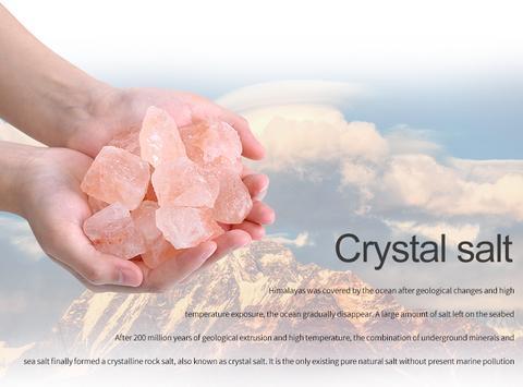 Hands holding pink crystal salt with a mountainous background