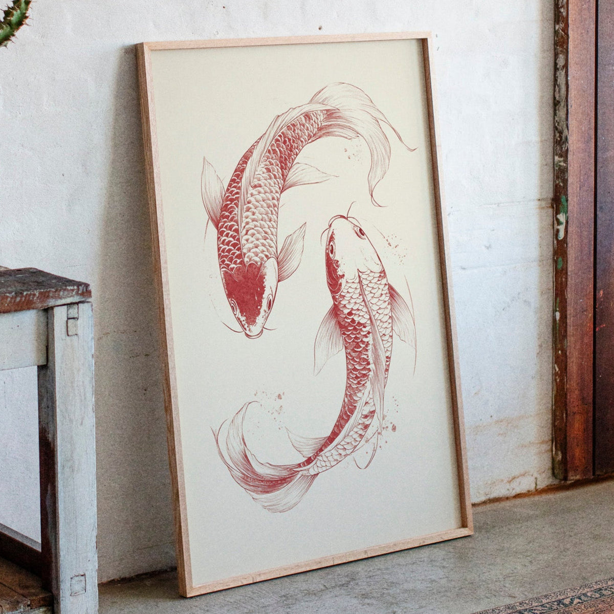 Framed artwork of two koi fish on a textured wall.