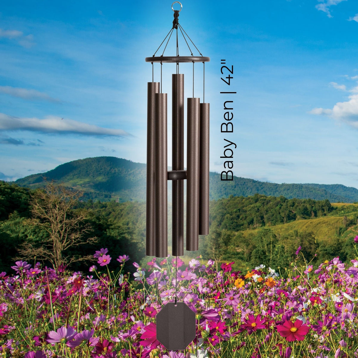 Wind chime labeled 'Baby Ben 42"' in a scenic outdoor setting with flowers and mountains.