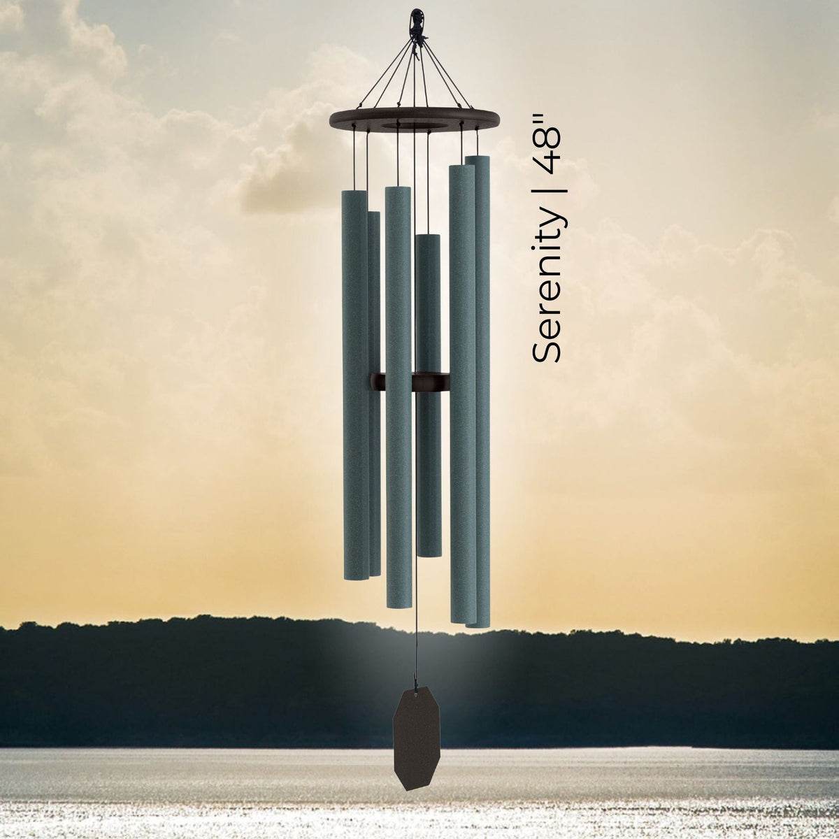 Wind chime with 'Serenity' and size '48”' against a sunset sky.