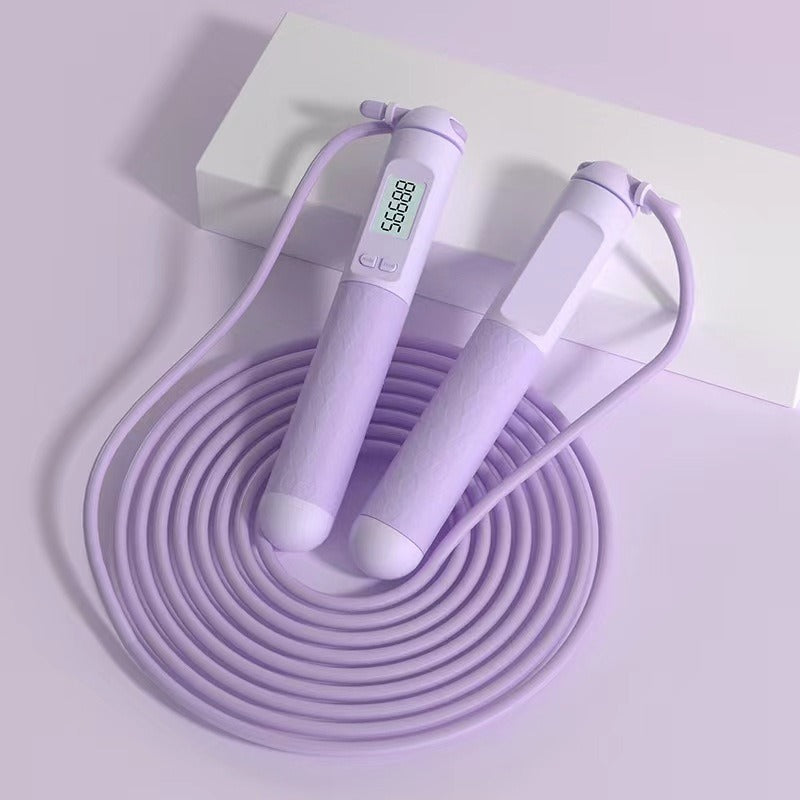 A light purple digital jump rope with two textured handle grips, one featuring a small digital display screen, coiled on a solid white background.