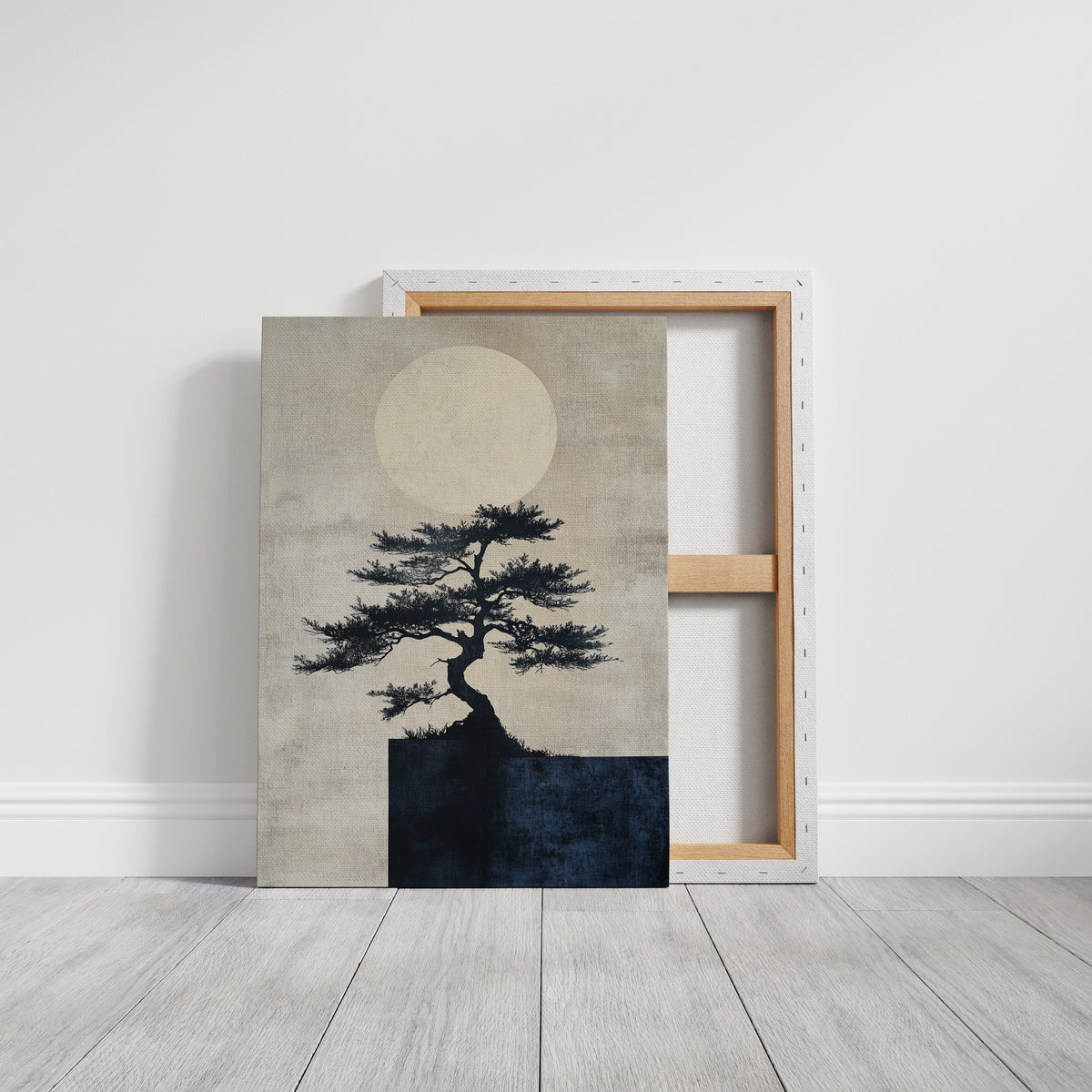 Framed artwork of a tree silhouette against a moonlit sky on a white wall.