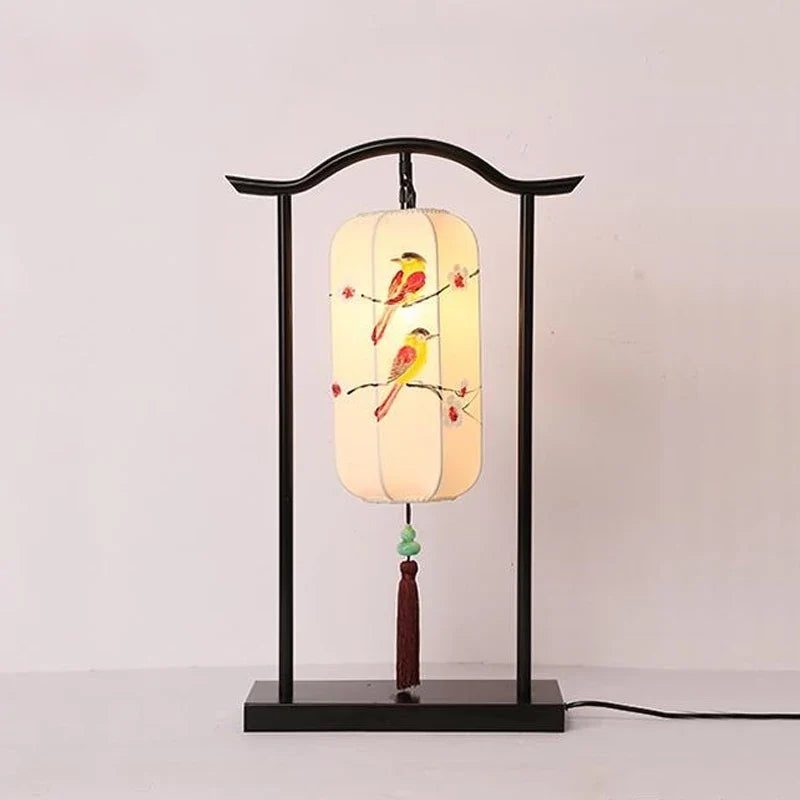 Decorative table lamp with birds on a branch design on a white background