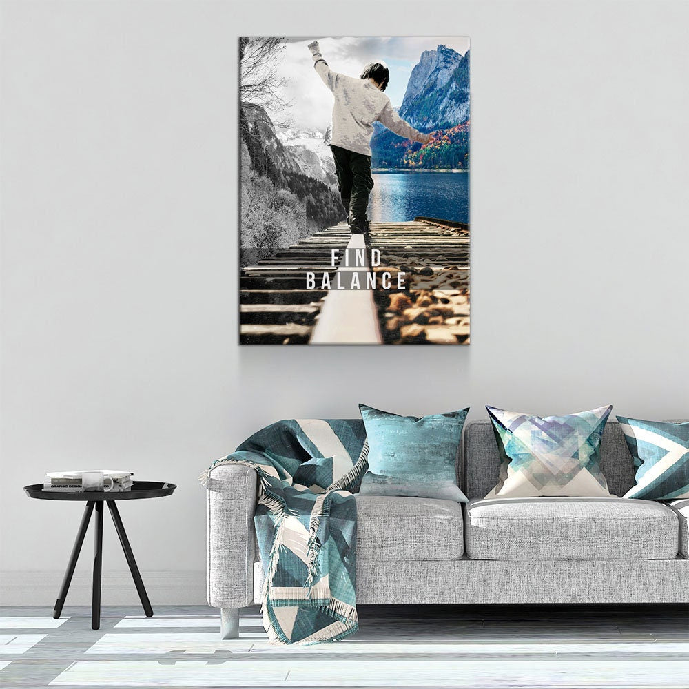 Living room with a sofa, decorative pillows, and a wall art print of a person on a bridge over a lake.