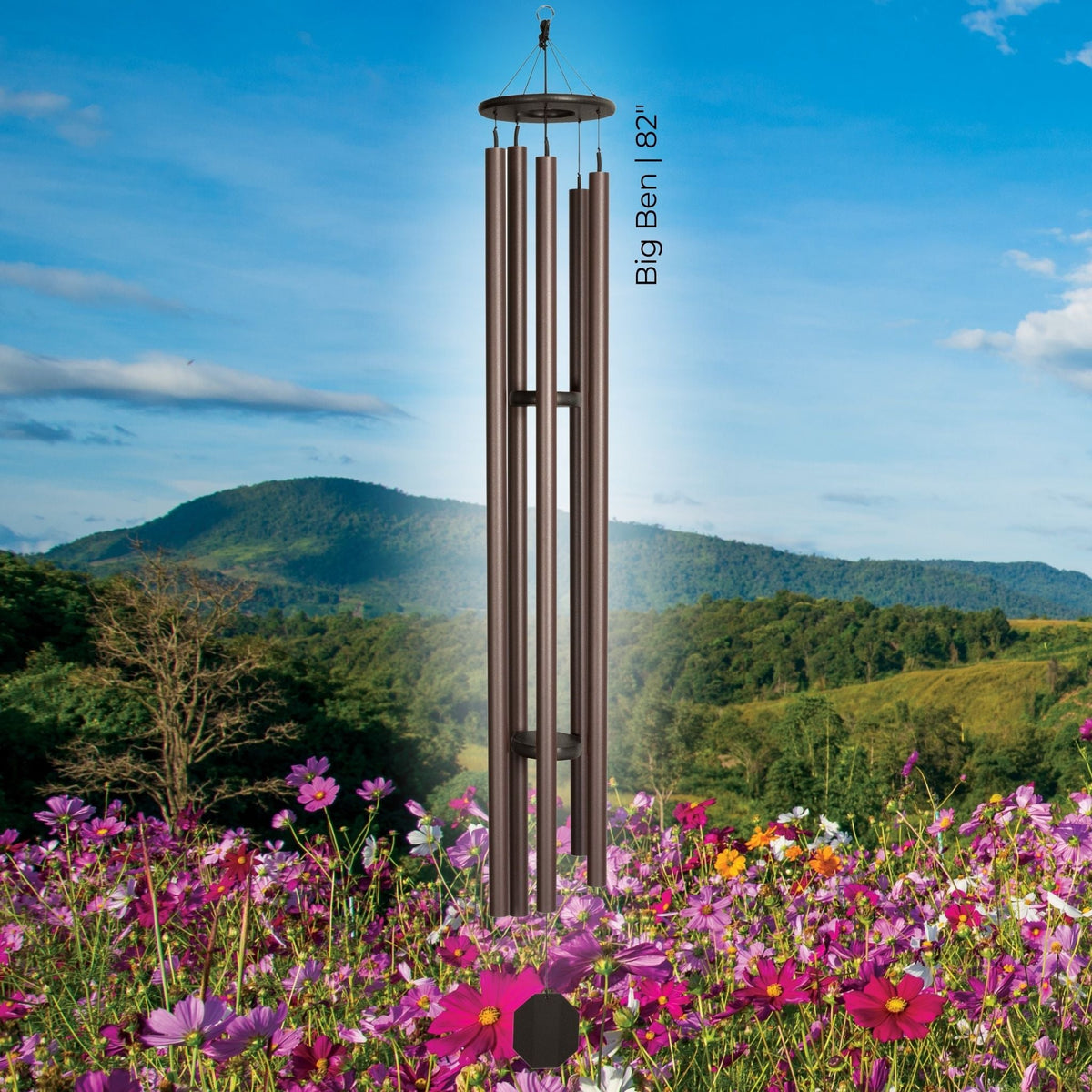 Wind chime in a field of flowers with mountains in the background