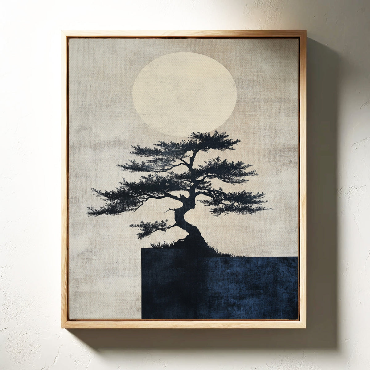 Framed artwork of a tree silhouette against a moonlit sky on a textured wall.