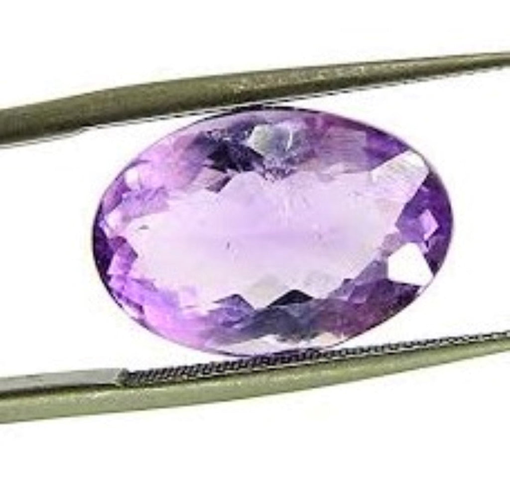 Tweezers holding a Brazilian amethyst in an elegant oval cut