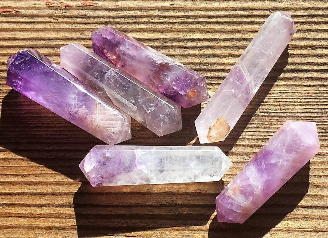 Set of amethyst crystal sticks on a wooden surface