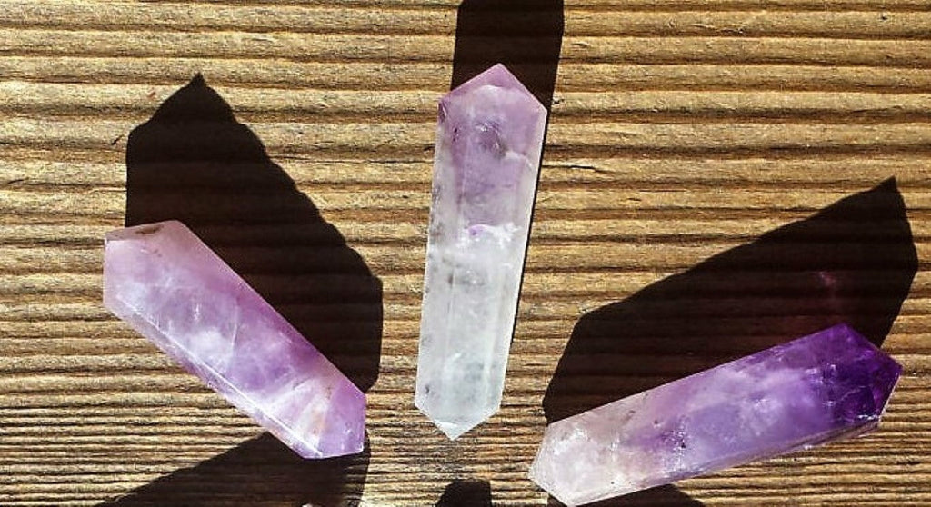 Three crystal sticks on a wooden surface