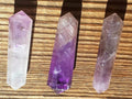 Three crystal sticks on a wooden surface