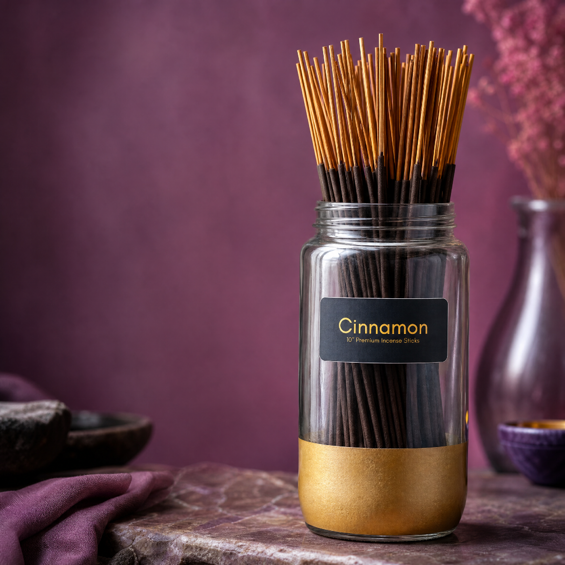 A jar of Cinnamon incense sticks next to a small vase of flowers.