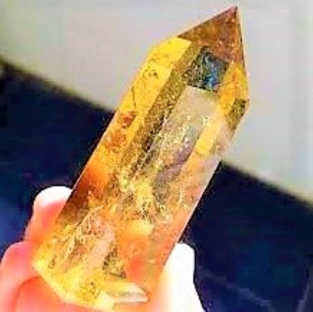 A hand holding a Citrine Crystal Obelisk Gem