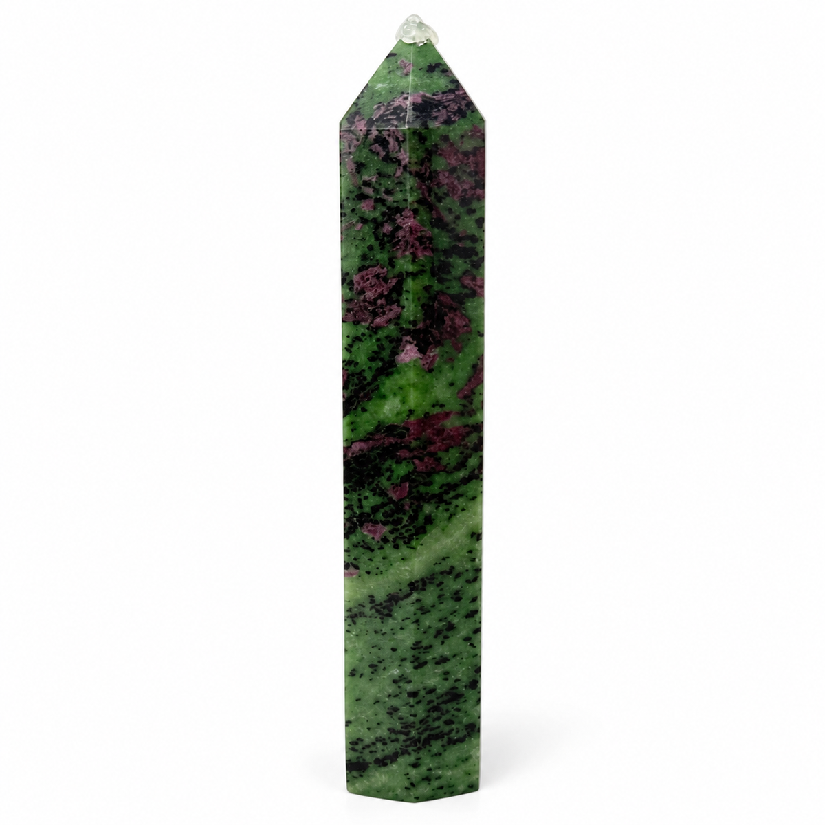 A polished natural crystal obelisk featuring a green body with prominent dark brown and magenta-purple matrix patterns, topped with a clear quartz point, shown on a white background.