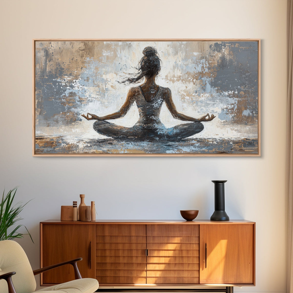Framed artwork of a meditating figure on a wall above a wooden cabinet.