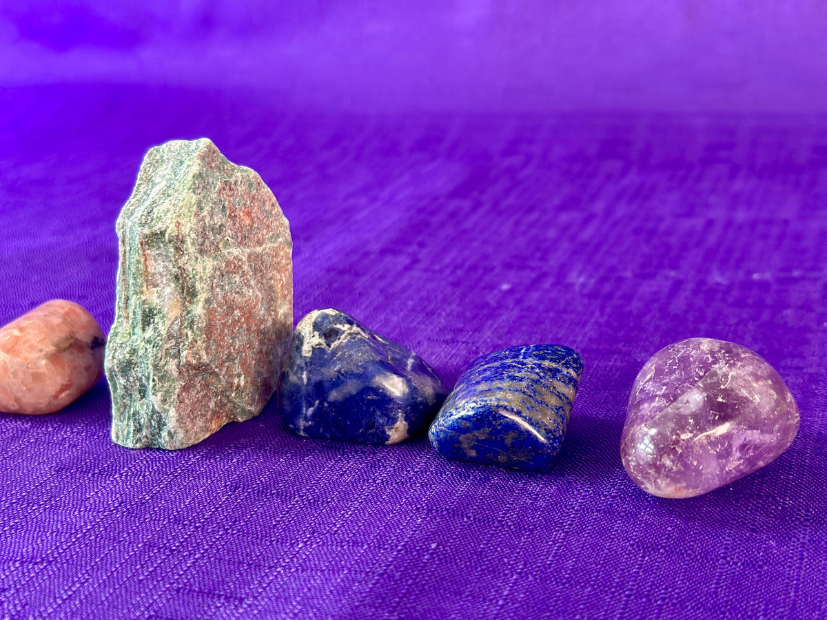 Five gemstones stones on a purple fabric