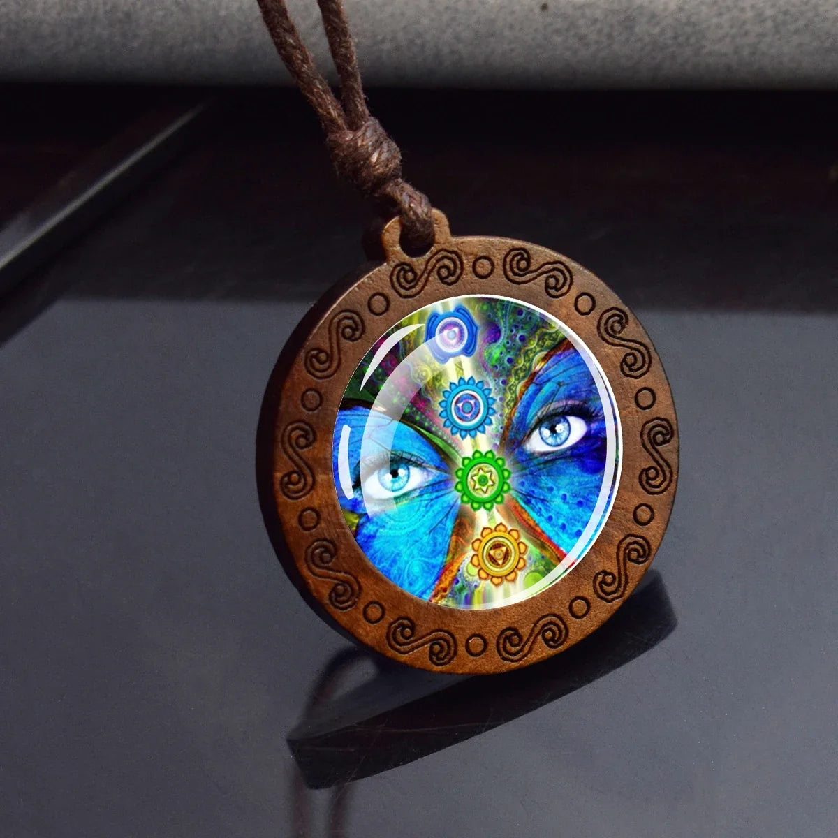 Wooden pendant with colorful design on a dark surface