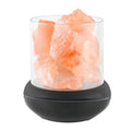 Himalayan salt lamp with clear glass shade and black base on a white background