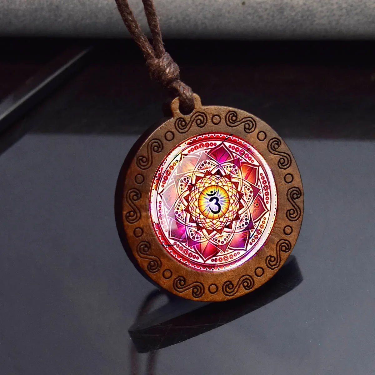 Decorative pendant with mandala design on a dark surface