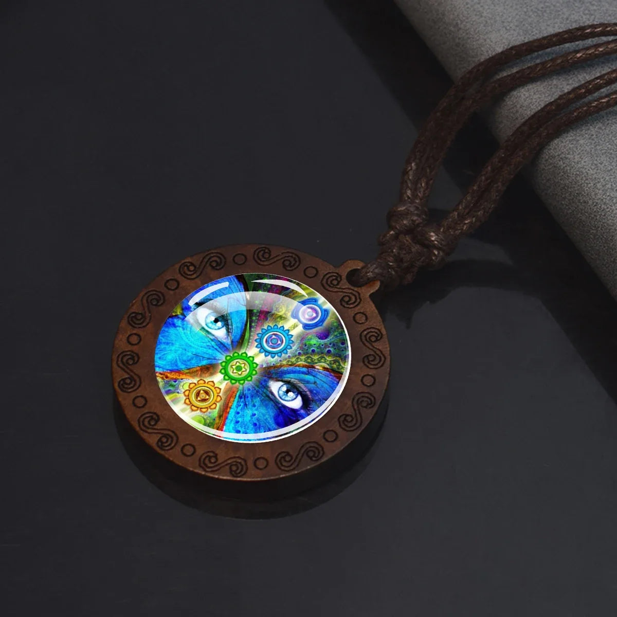 Necklace with a round pendant featuring colorful eye design on a dark background