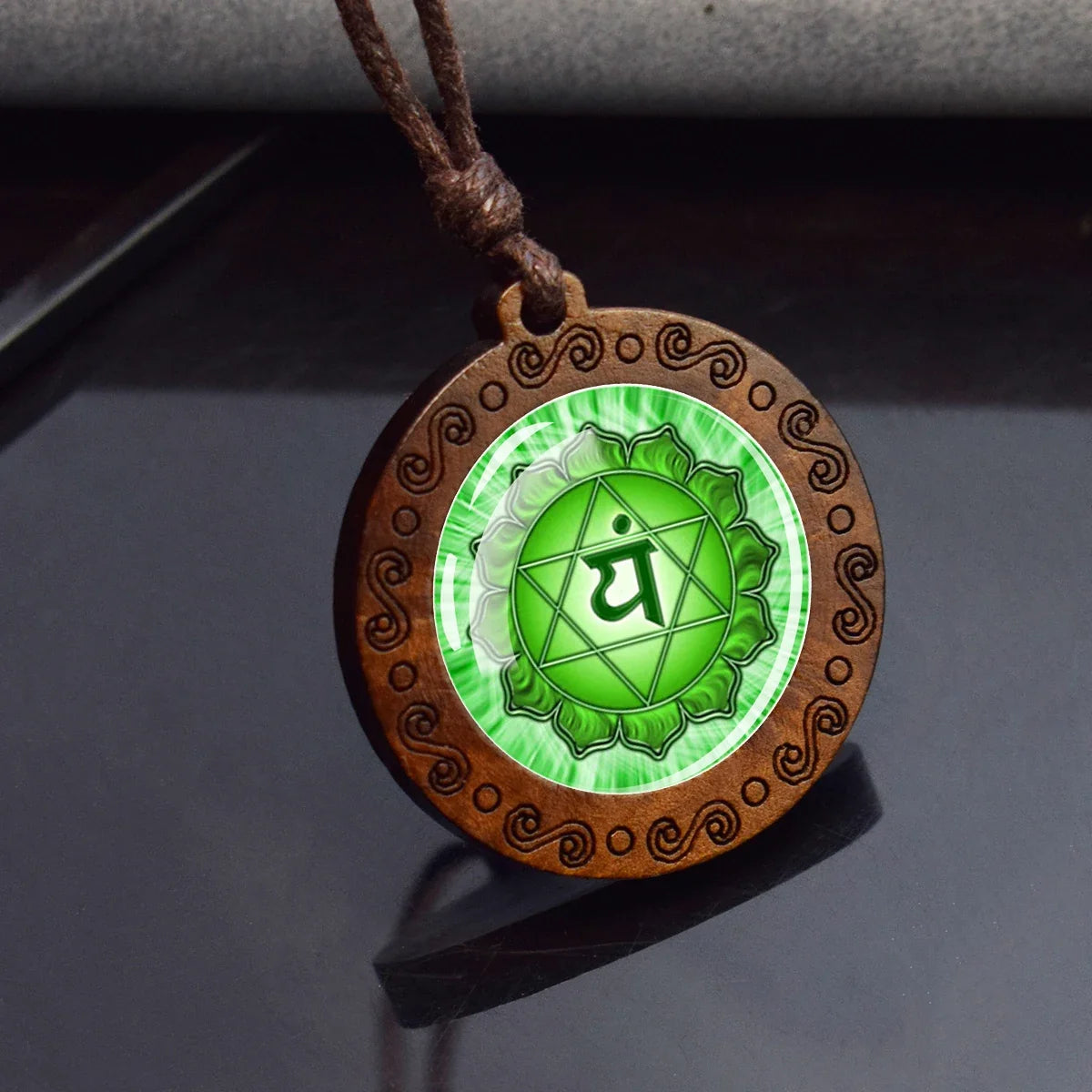 Wooden pendant with green emblem on a dark surface