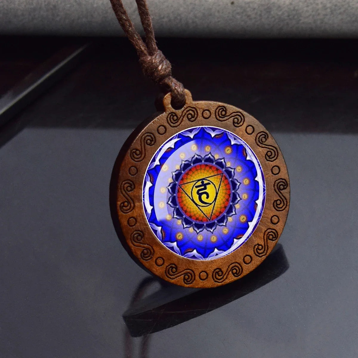 Decorative pendant with mandala design on a dark surface