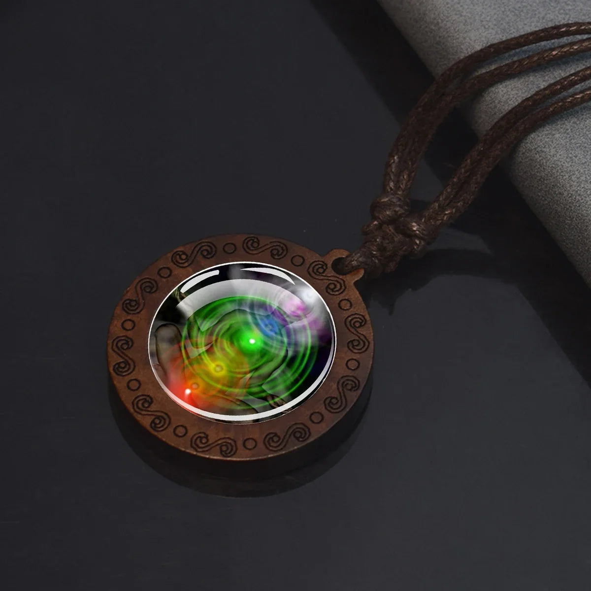Necklace with a wooden pendant featuring a colorful, swirling design on a dark background