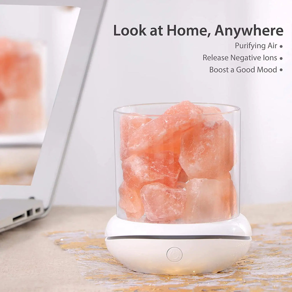 Photo of a Natural Himalayan Salt Lamp on a white background next to a laptop computer
