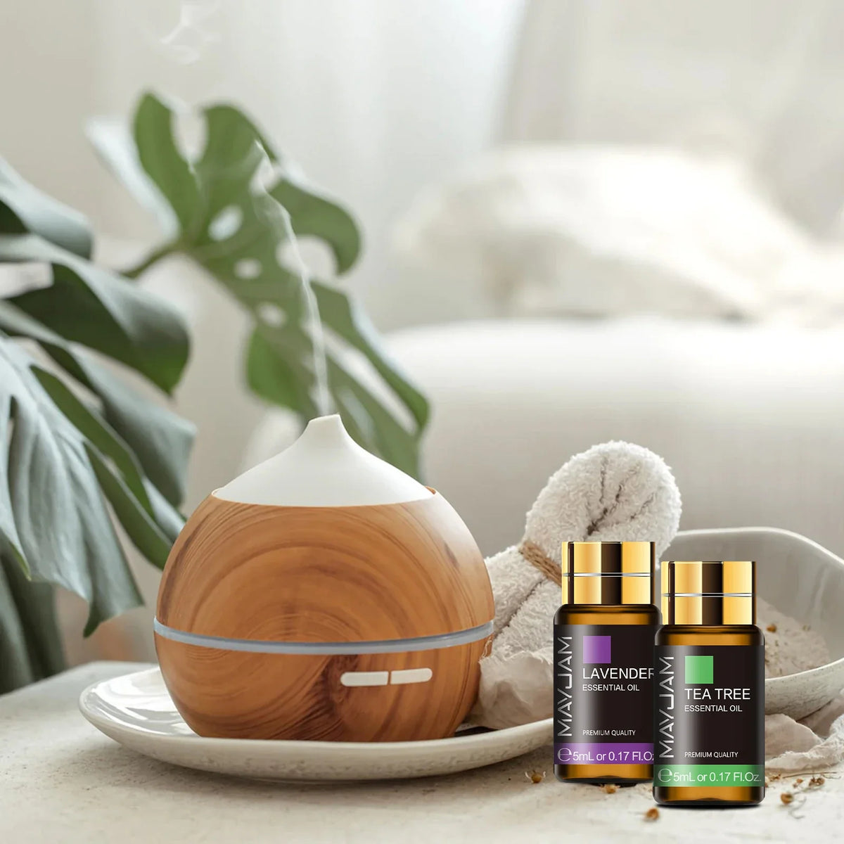 Wooden diffuser and essential oil bottles on a table with a plant in the background