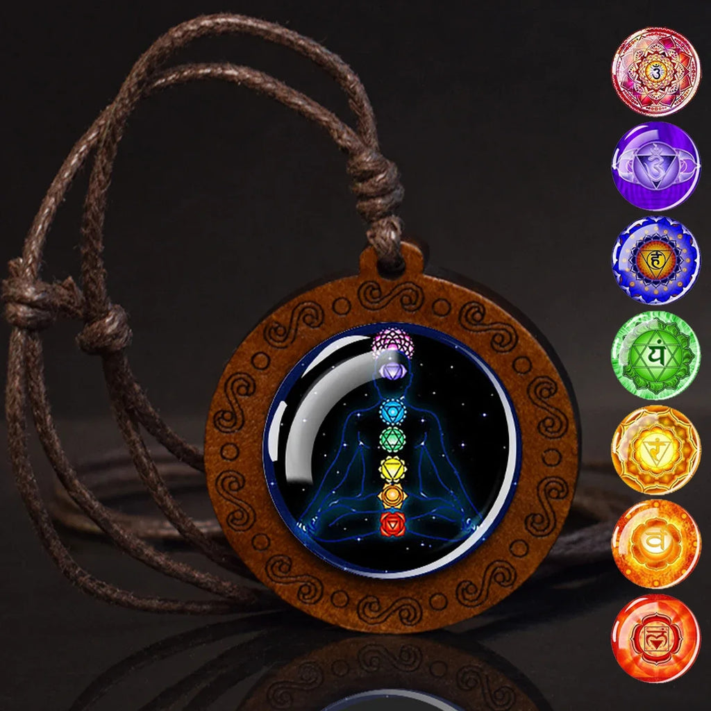 Wooden pendant with chakra diagram and colorful chakra symbols on a dark background