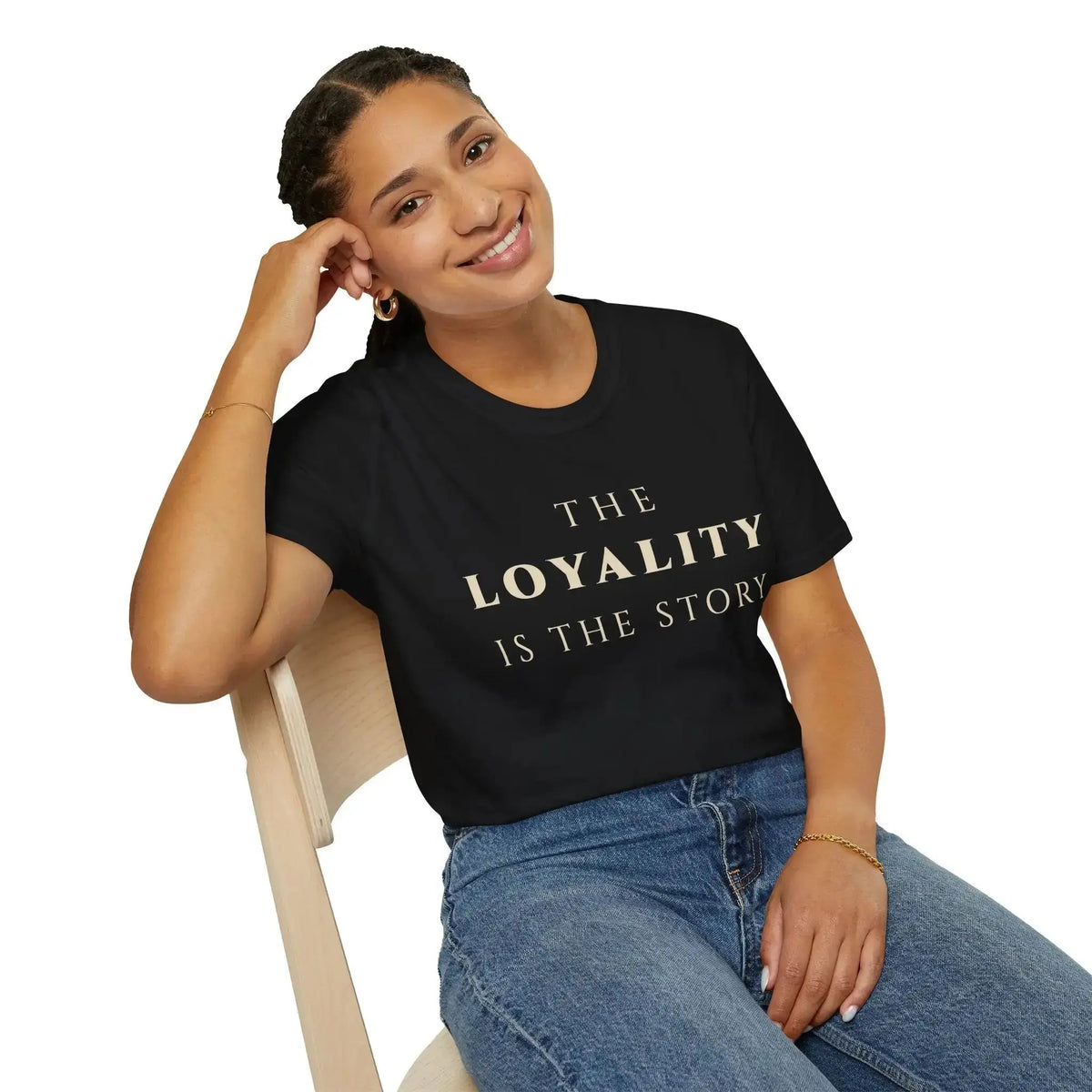 Person wearing a black t-shirt with a colorful graphic design, sitting on a white background