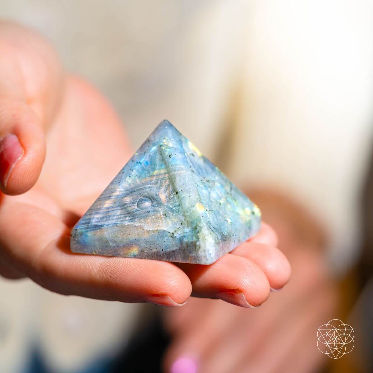 Person holding a triangular crystal with a blurred background