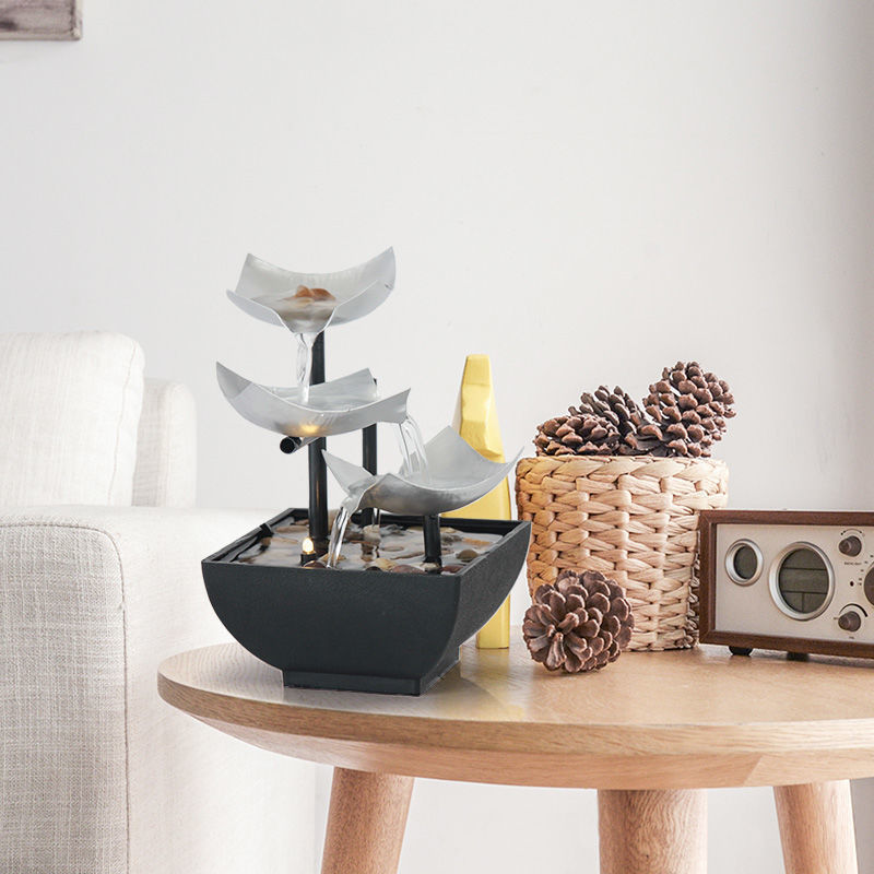 Feng Shui water fountain on a wooden table with decorative elements