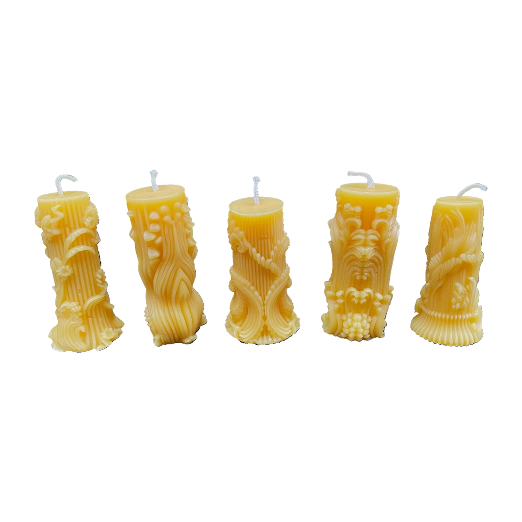 Five carved raised leaf and floral design beeswax candles on a white background.