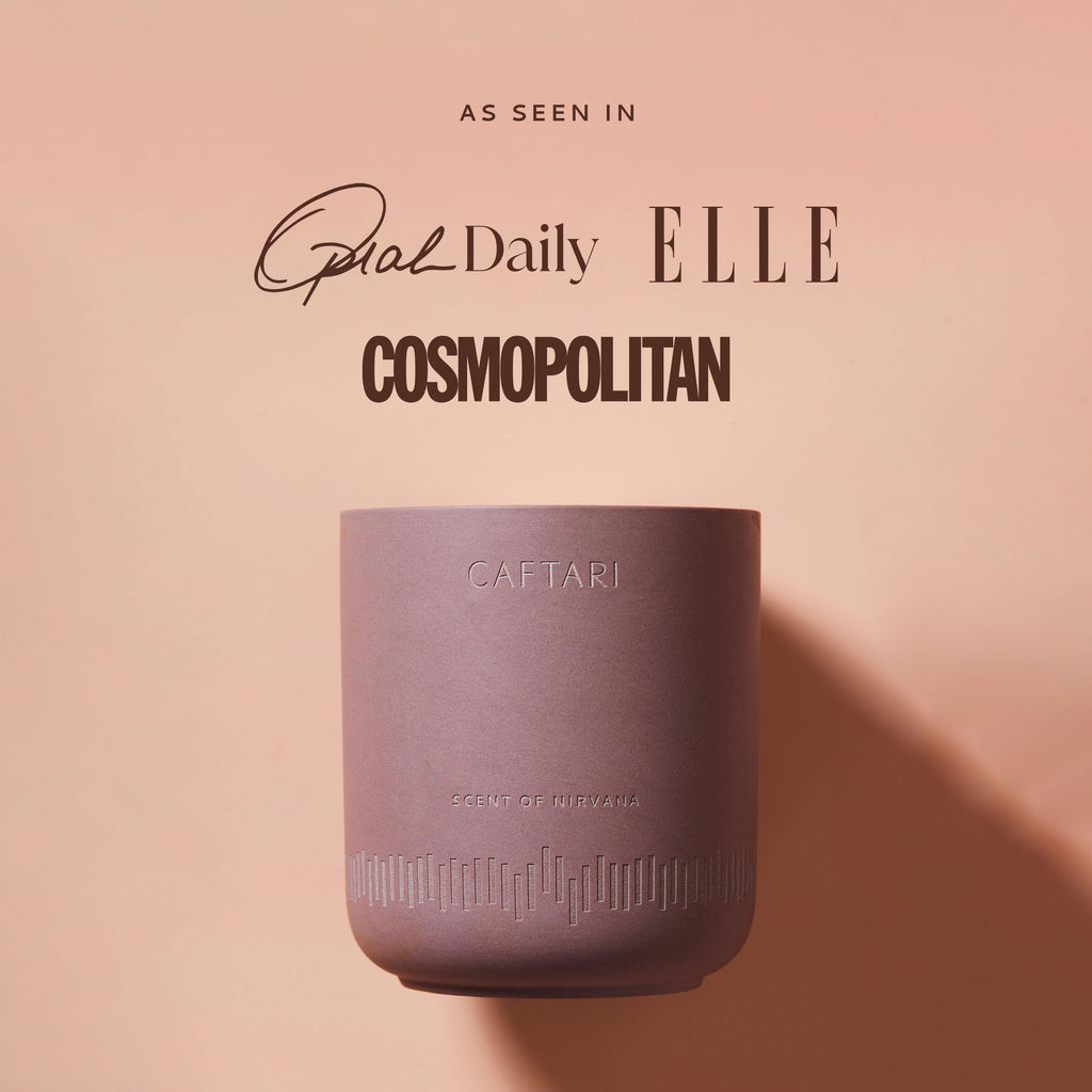 Purple candle with 'CAFTARI' branding on a pink background, featuring magazine titles.