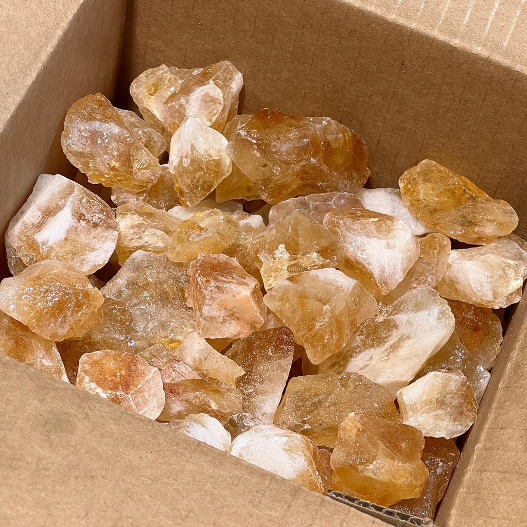 Large rough citrine crystal stones in bulk showing natural variations in color and shape