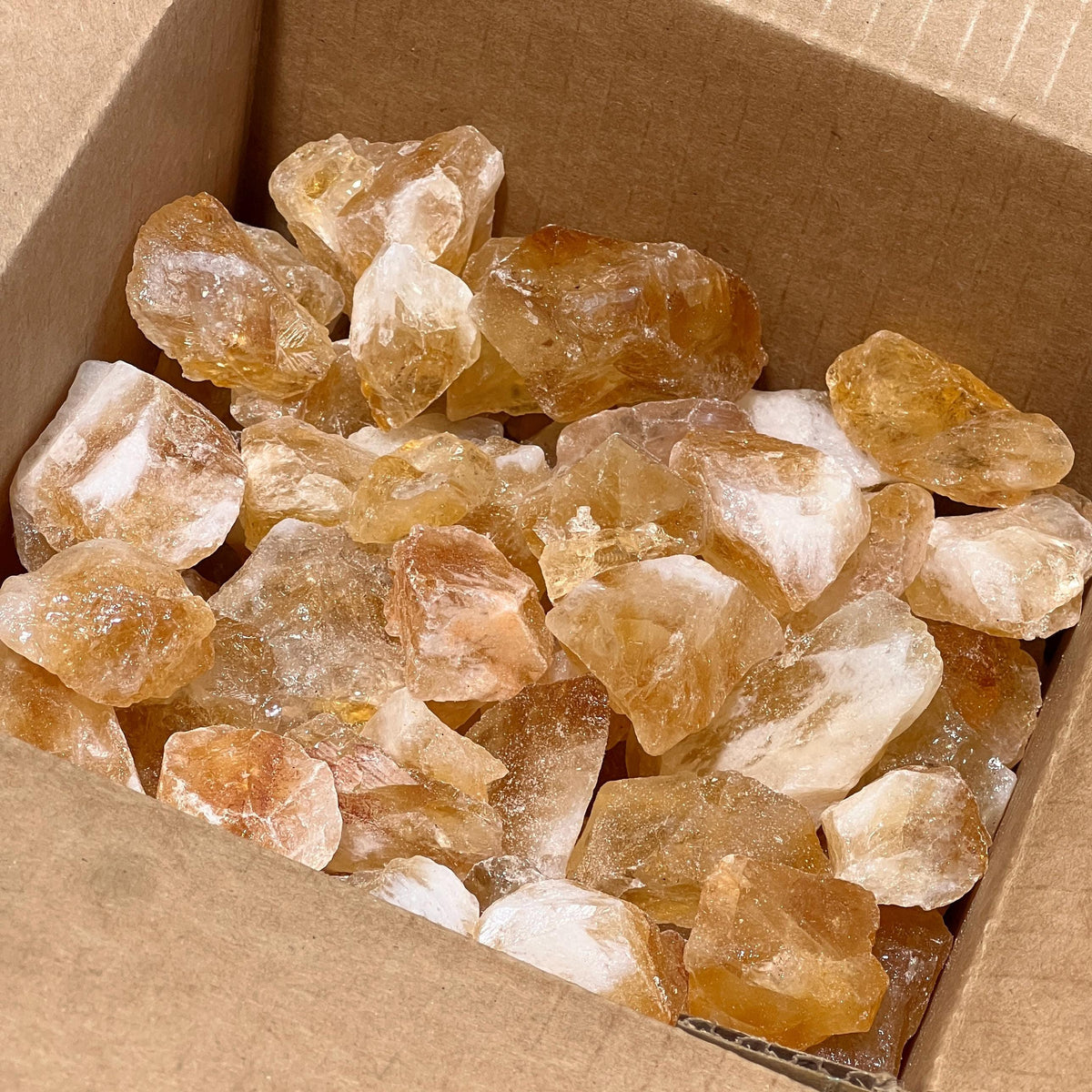 Large rough citrine crystal stones in bulk showing natural variations in color and shape