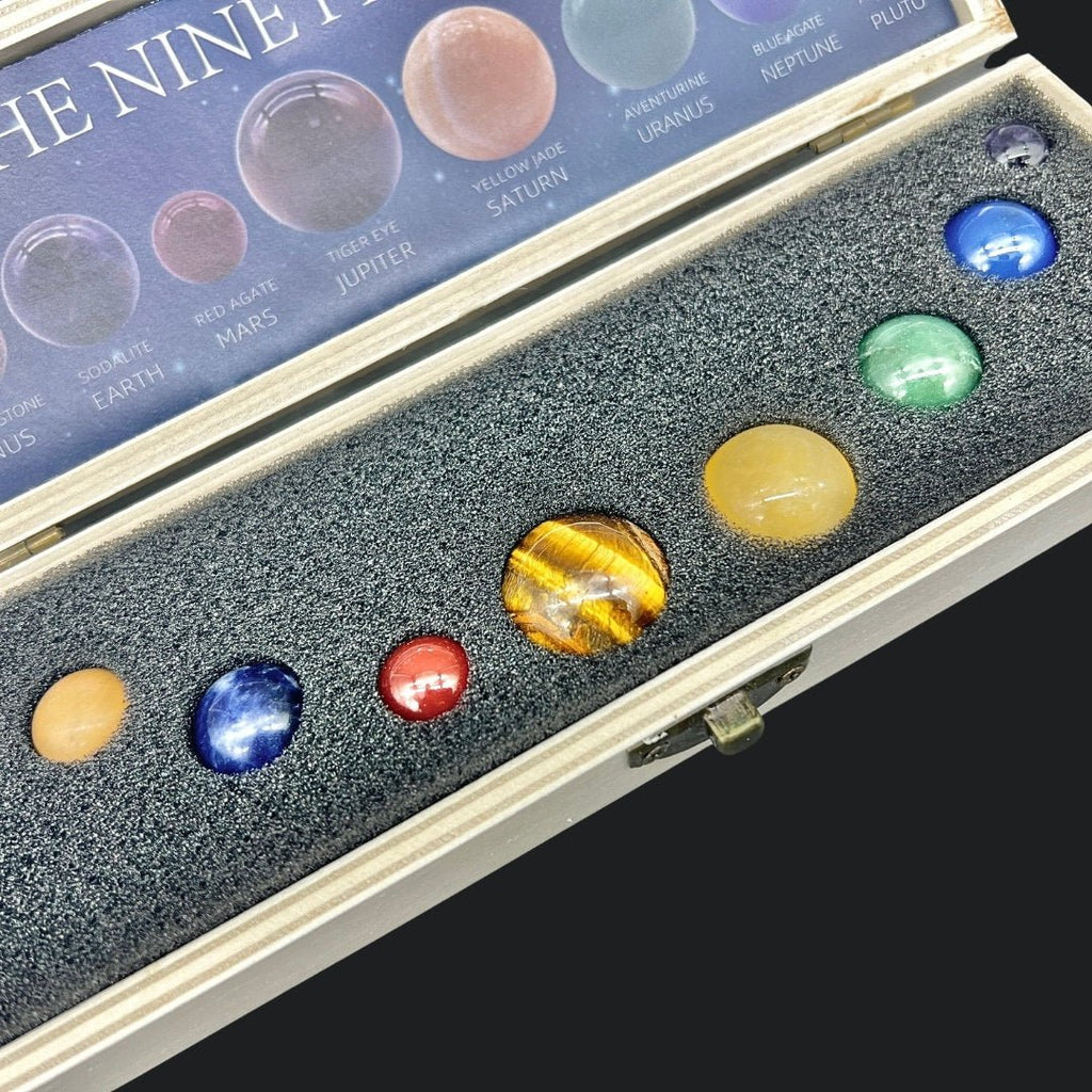 Collection of model planets in a display case with a box labeled 'The Nine Planets'.