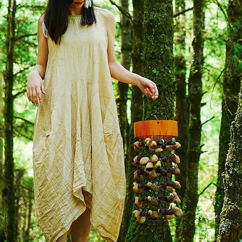 Picture of a woman holding a seed pod wind chime with a closer view of the wind chime.
