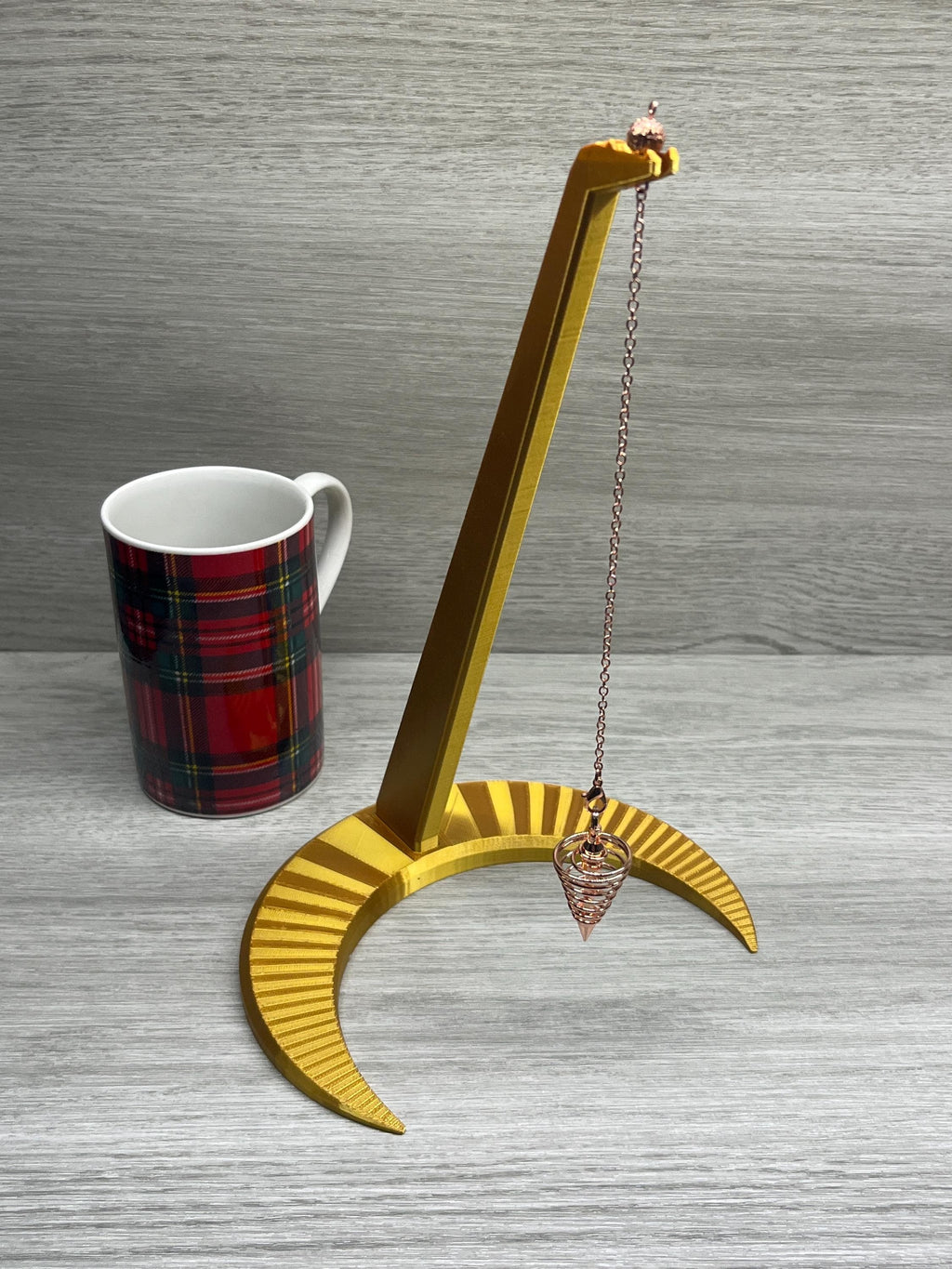Large Pendulum Moon Stand, next to a coffee cup.