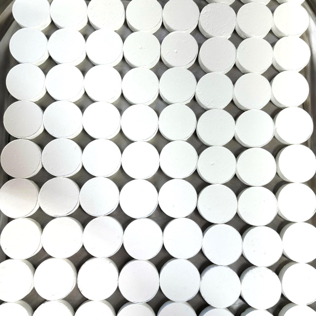 A dense grid of small white cylindrical discs or caps arranged tightly together, filling the frame.